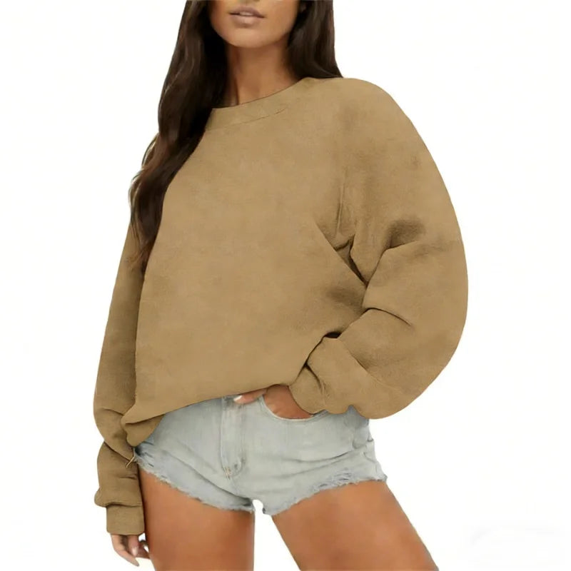 Person wearing a beige sweatshirt and denim shorts on a white background