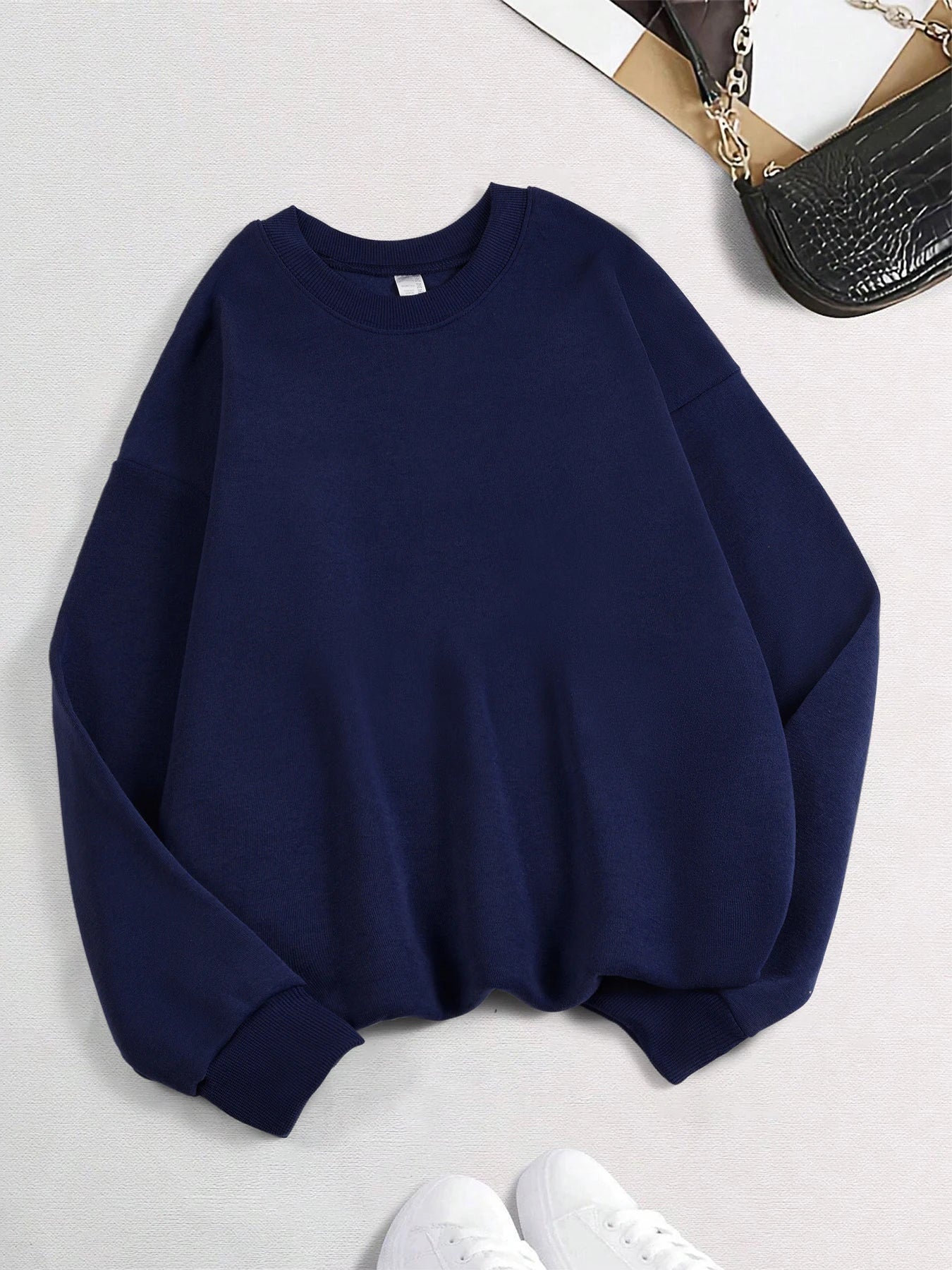 Navy blue sweatshirt on a light gray background