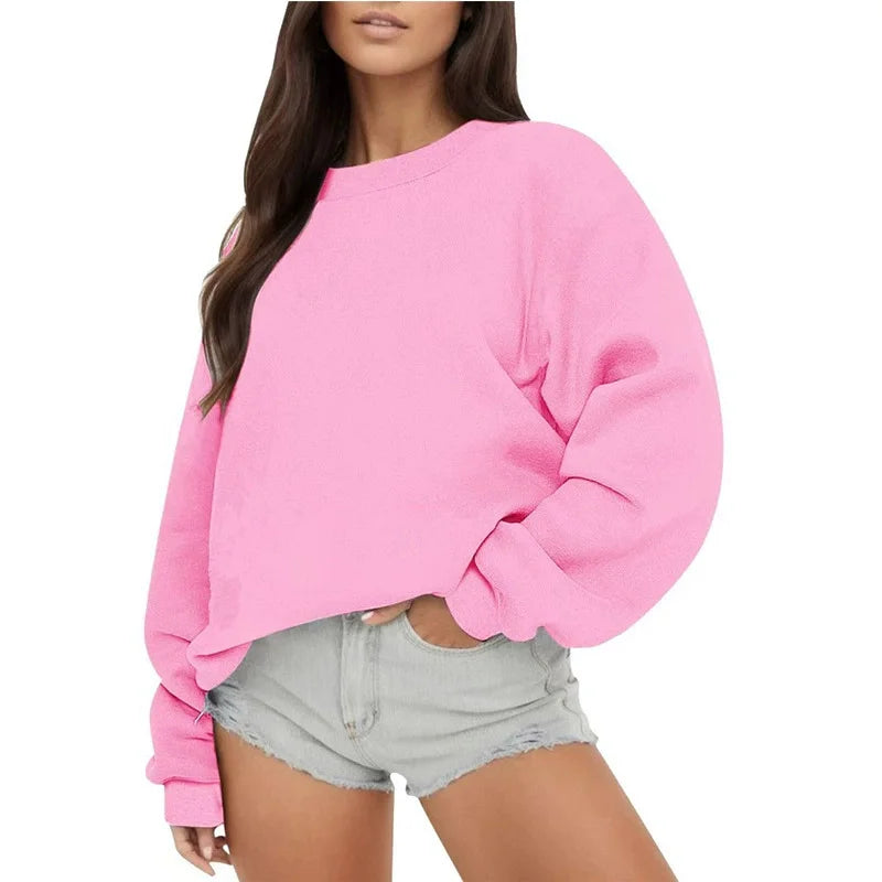 Person wearing a pink sweatshirt and light gray shorts on a white background