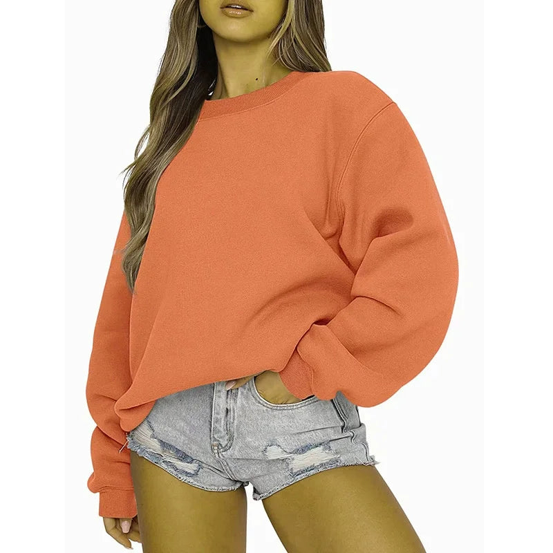 Person wearing an orange sweatshirt and denim shorts on a white background