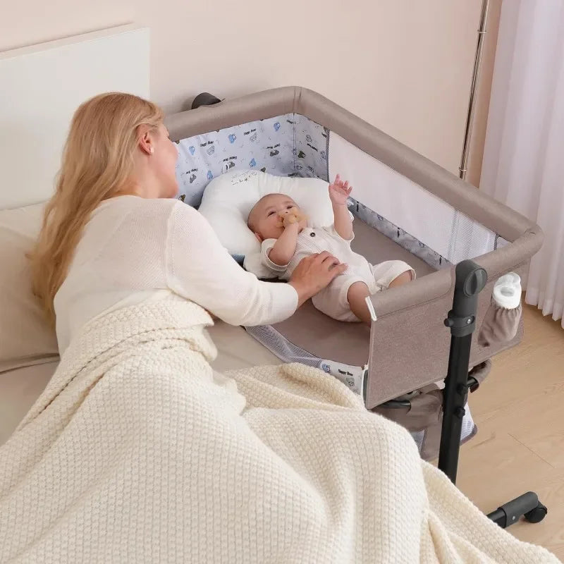 Woman lying on a bed next to a baby in a crib, both wearing white outfits.