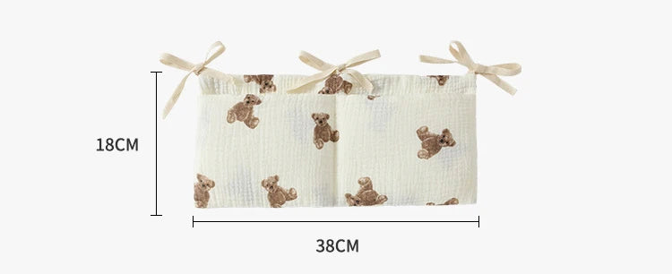 Baby crib bumper with teddy bear pattern and measurements on a white background