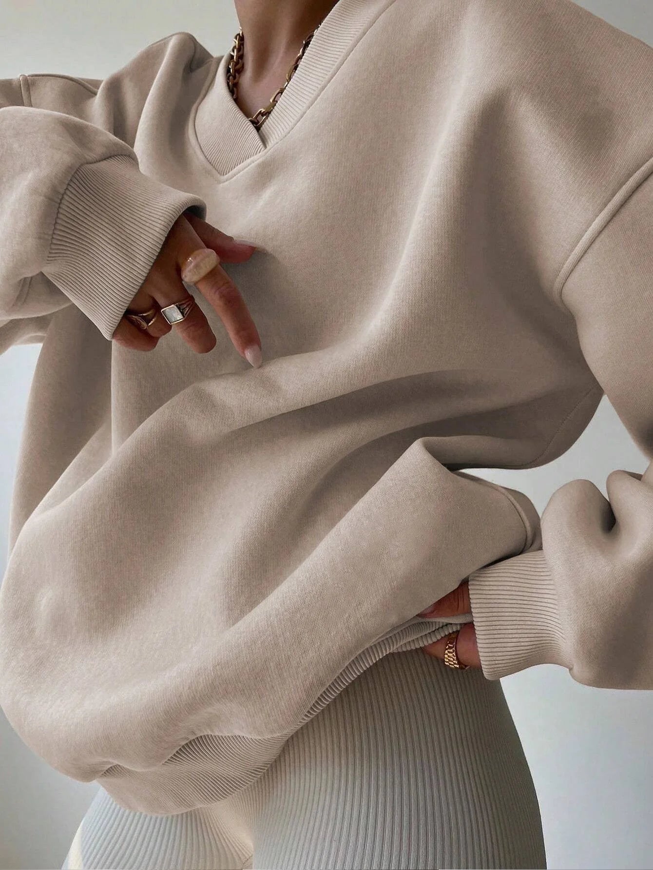 Beige sweater worn by a person with a neutral background