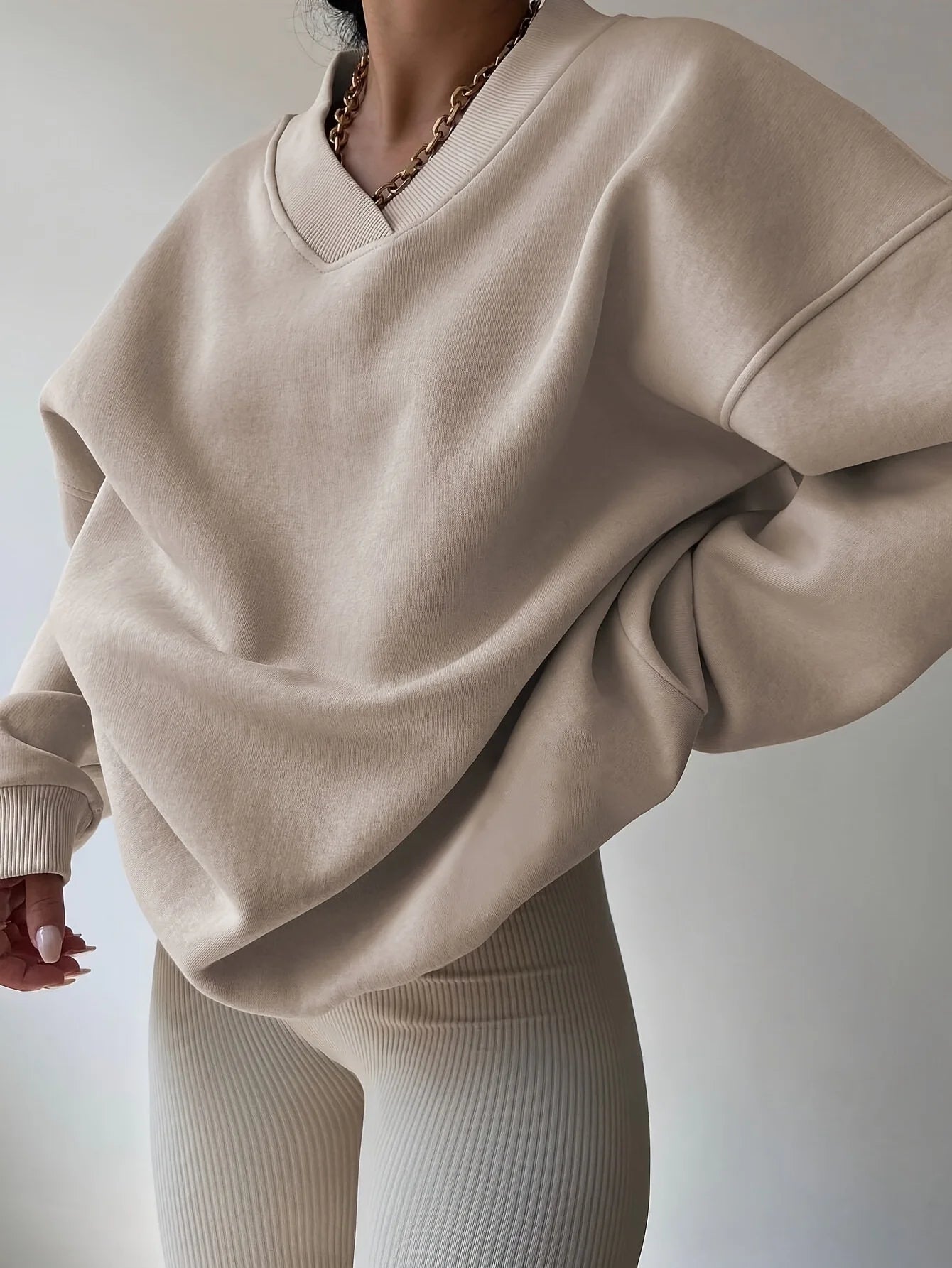 Beige sweatshirt worn by a person on a plain background