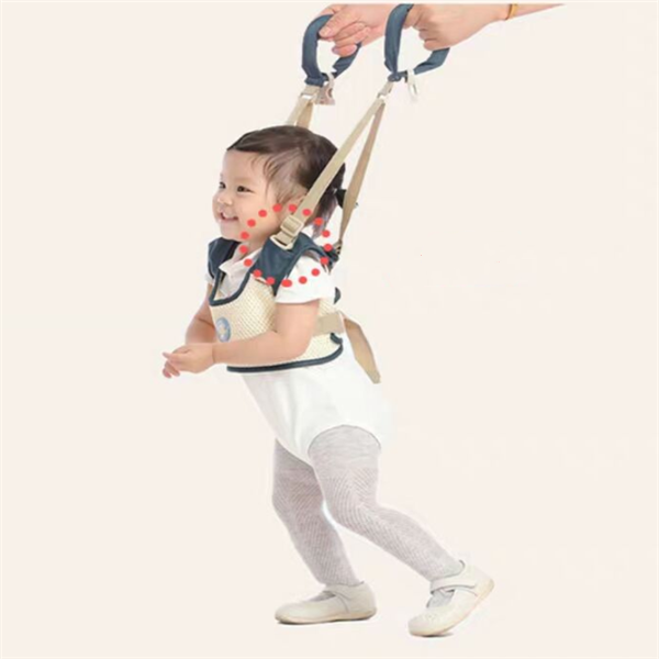 Child using a baby walking harness with a plain background