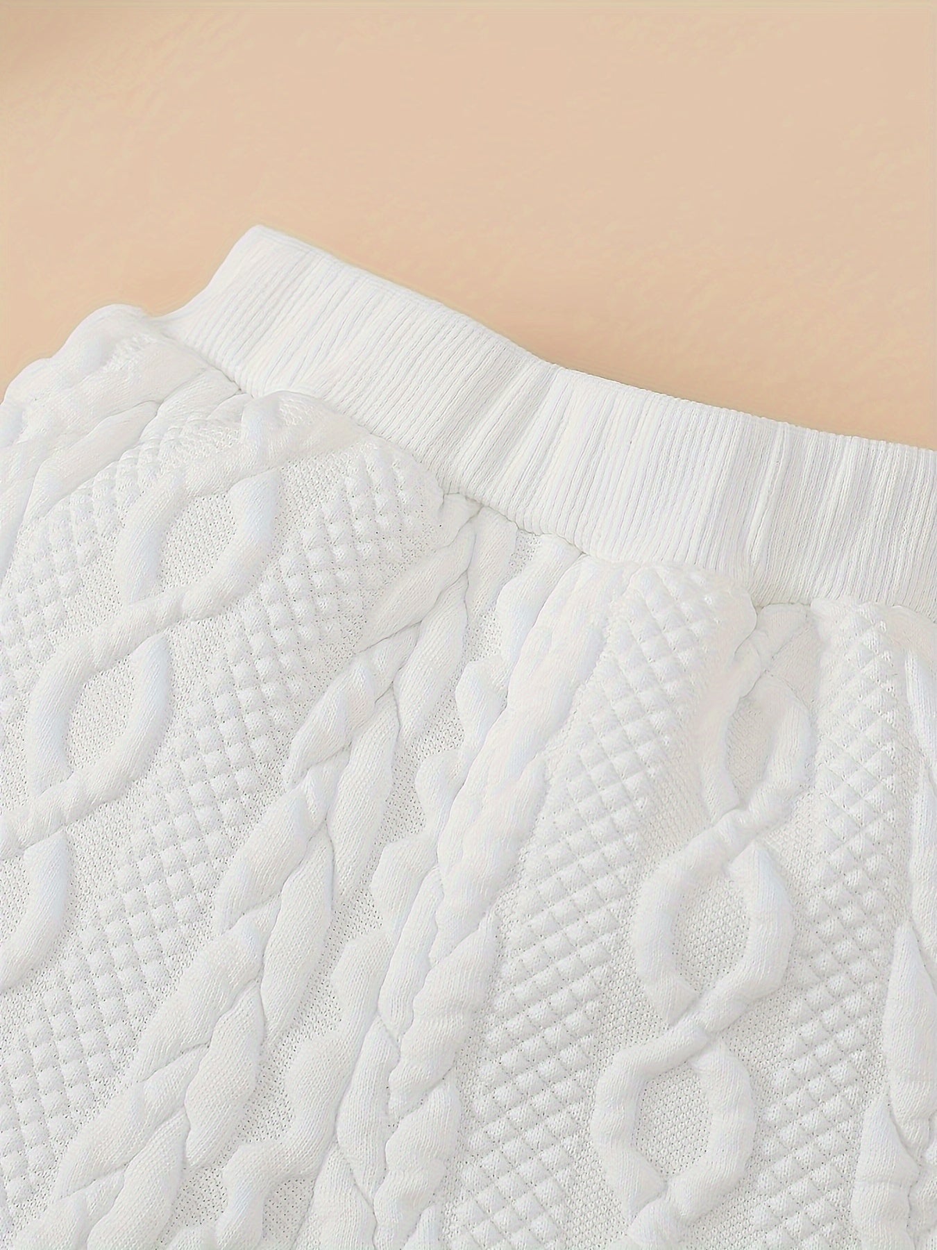 Close-up of a textured white fabric with a beige background